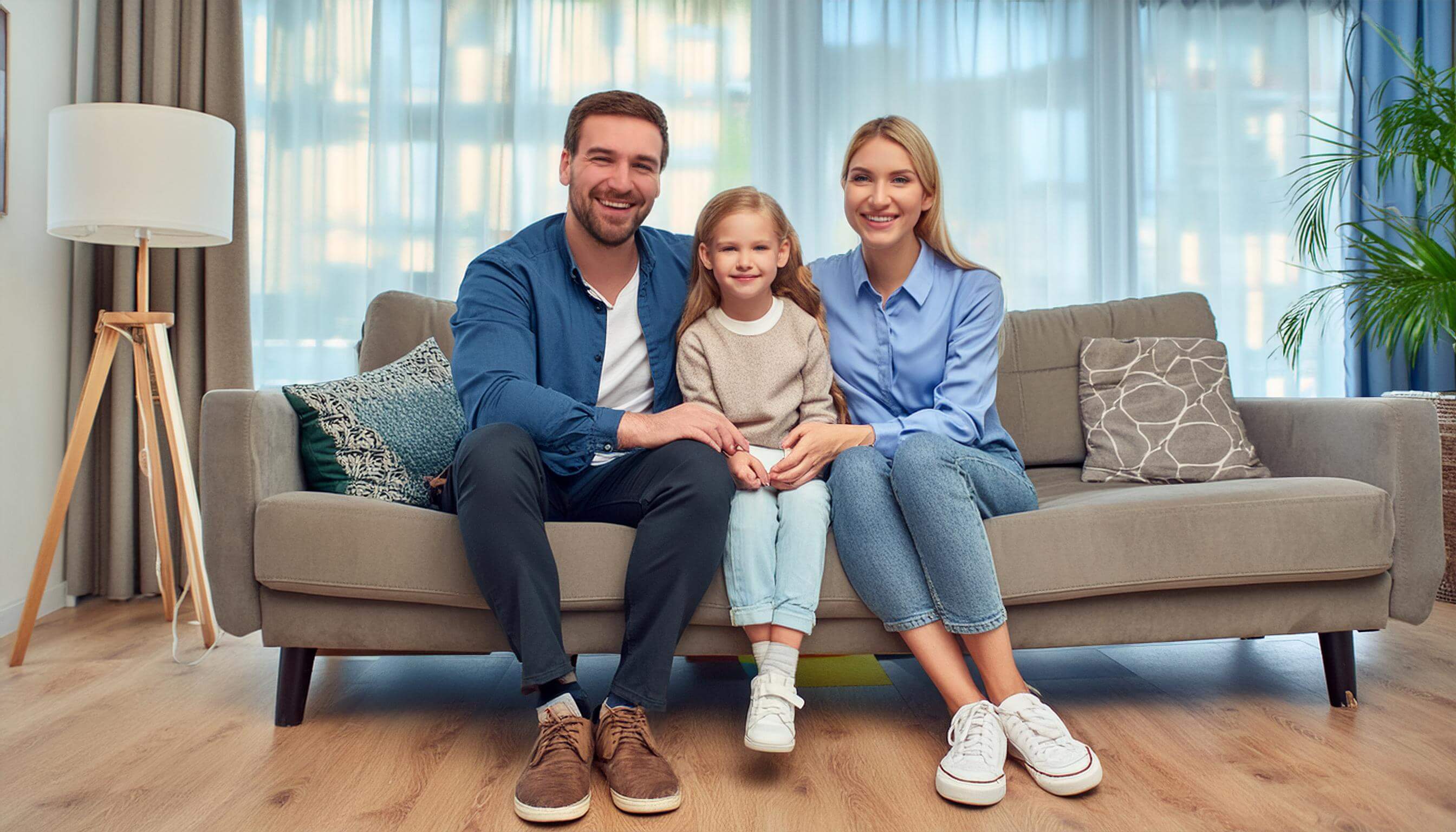 Familie, mit Vater, Mutter und Tochter, sitzt auf einem Sofa